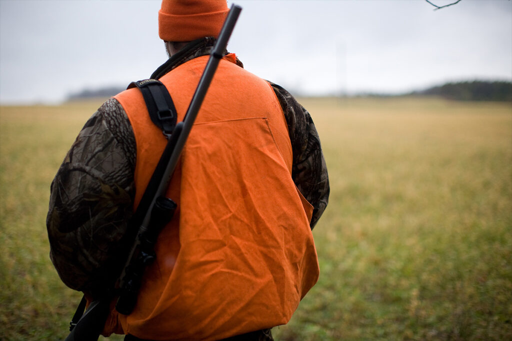 Deer hunting Man in orange and black backpack